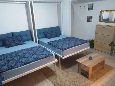 two beds in a room with a couch and a table at Skadarska Blue in Belgrade