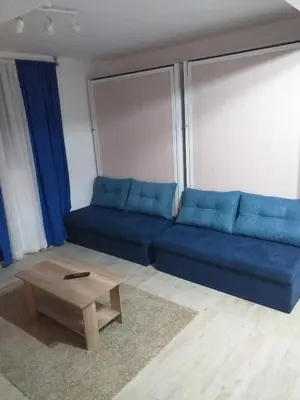 a living room with a blue couch and a coffee table at Skadarska Blue in Belgrade