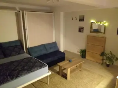 a living room with a blue couch and a table at Skadarska Blue in Belgrade