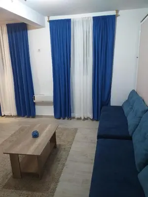 a living room with blue curtains and a blue couch at Skadarska Blue in Belgrade