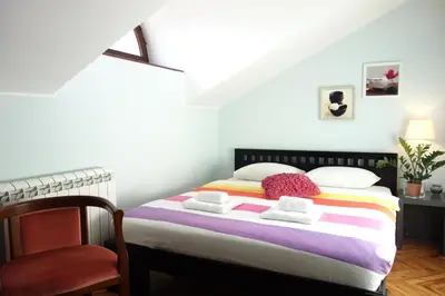 a bedroom with a bed and a chair in a room at Villa Quantum Beograd in Belgrade