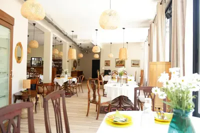 a dining room with tables and chairs and lights at Villa Quantum Beograd in Belgrade