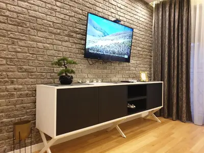 a living room with a tv on a brick wall at Luxury Spa Suite in Belgrade