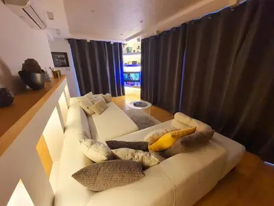 a living room with a white couch with pillows at Penthouse Lux in Belgrade