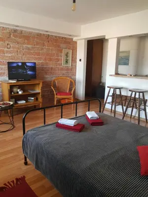 a bedroom with a bed and a brick wall at Alexandar in Belgrade