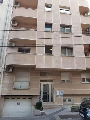 a tall building with two garages in front of it at Luka Lux apartman in Belgrade