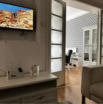 a living room with a tv on a wall at Bloom apartments in Belgrade