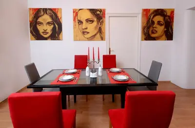 a dining room with a black table and red chairs at Bloom apartments in Belgrade