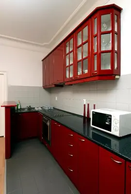 a kitchen with red cabinets and a microwave at Bloom apartments in Belgrade