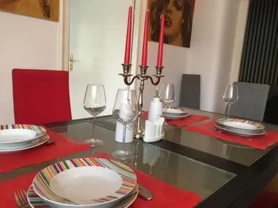 a dining room table with plates and glasses and red napkins at Bloom apartments in Belgrade