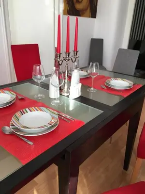 a dining room table with red napkins and red candles at Bloom apartments in Belgrade