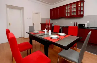 a kitchen with a table and red chairs in a room at Bloom apartments in Belgrade