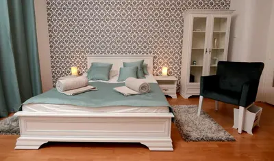 a bedroom with a white bed and a chair at Bloom apartments in Belgrade