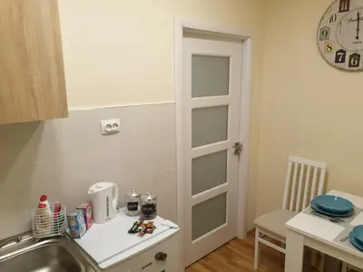 a kitchen with a sink and a table and a clock at Apartment Marija in Belgrade