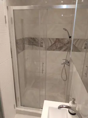 a shower with a glass door next to a sink at Alba Graeca in Belgrade