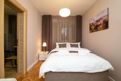 a bedroom with a large white bed and a window at Vracar Vuk 1 in Belgrade