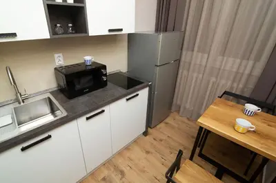 a small kitchen with a refrigerator and a table at Vracar Vuk 1 in Belgrade