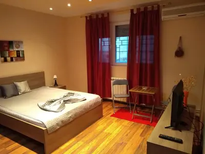 a bedroom with a bed and a television and a desk at Castel Bianco in Belgrade