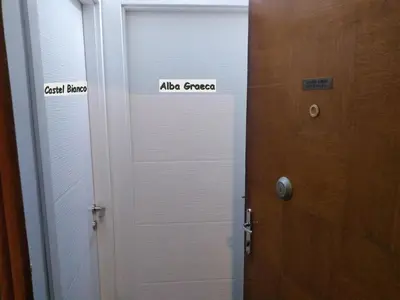 a door with two signs on it next to a wooden door at Castel Bianco in Belgrade