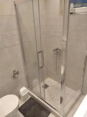 a bathroom with a glass shower with a toilet at Castel Bianco in Belgrade