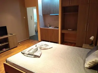 a bedroom with a bed and a room with a tv at Castel Bianco in Belgrade