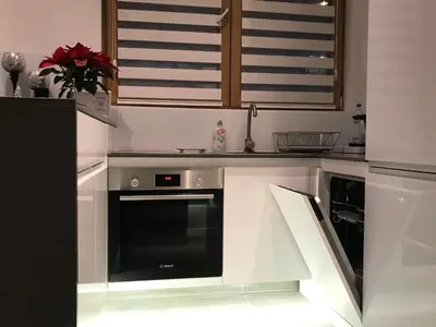 a kitchen with white cabinets and a dishwasher at INNA Luxe & Wine- Central Belgrade Apartments in Belgrade
