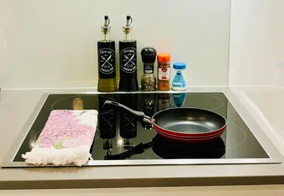 a stove top with a frying pan and a pot on it at LIRRA LUXE - Central Belgrade Apartments in Belgrade