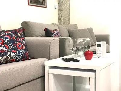 a living room with a couch and a table with a wine glass at LIRRA LUXE - Central Belgrade Apartments in Belgrade