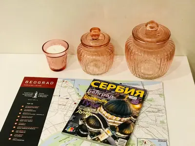 two vases and a magazine sitting on a table at LIRRA LUXE - Central Belgrade Apartments in Belgrade