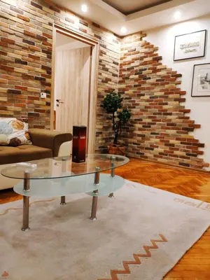 a living room with a glass table and a brick wall at V2 with Love - Vintage Modern and Spacious in Belgrade