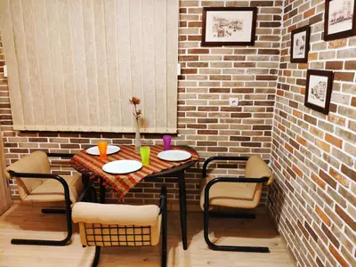 a table and chairs in a room with a brick wall at V2 with Love - Vintage Modern and Spacious in Belgrade