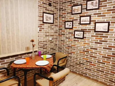a room with a table and chairs and a brick wall at V2 with Love - Vintage Modern and Spacious in Belgrade