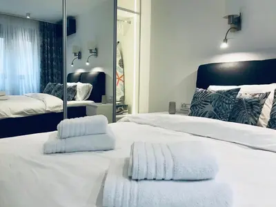 a bedroom with a large white bed and a mirror at SLAVNA - Luxe & Wine by the Fortress in Belgrade