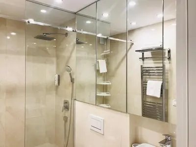 a bathroom with a shower and a sink and a mirror at SLAVNA - Luxe & Wine by the Fortress in Belgrade