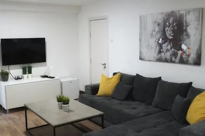 a living room with a gray couch and a tv at St.Sava apartment in Belgrade