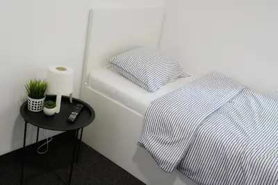 a white bed with a striped blanket and a table at St.Sava apartment in Belgrade
