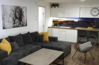 a living room with a couch and a kitchen at St.Sava apartment in Belgrade