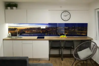 a kitchen with a counter with a clock on the wall at St.Sava apartment in Belgrade