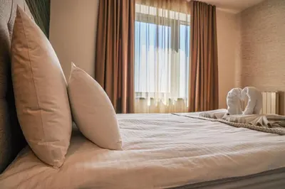 a bedroom with a bed with pillows and a window at Apartments Royal - Belgrade Waterfront in Belgrade