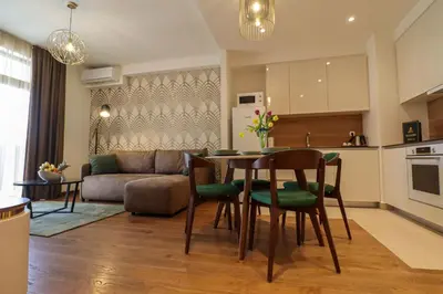 a kitchen and a living room with a table and chairs at Apartments Royal - Belgrade Waterfront in Belgrade