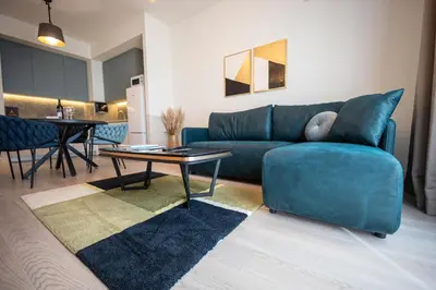 a living room with a blue couch and a table at Apartments Royal - Belgrade Waterfront in Belgrade