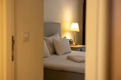 a bedroom with a bed with white pillows and a lamp at Apartments Royal - Belgrade Waterfront in Belgrade