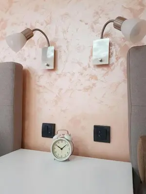 a clock sitting on a table next to two lights at Apartman DoDoLu in Belgrade