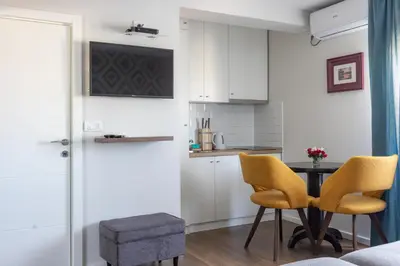 a kitchen with a table and two yellow chairs at Apartment Sovre in Belgrade
