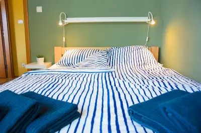 a blue and white bed with blue towels on it at Dunavski Kej in Smederevo
