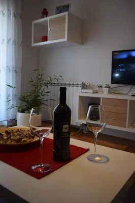 a bottle of wine and two glasses on a table at Dunavski Kej in Smederevo