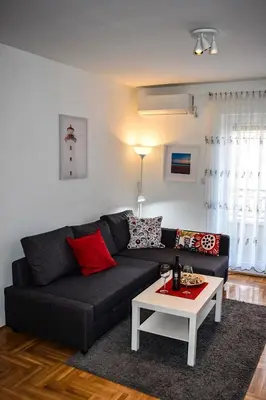 a living room with a black couch and a table at Dunavski Kej in Smederevo