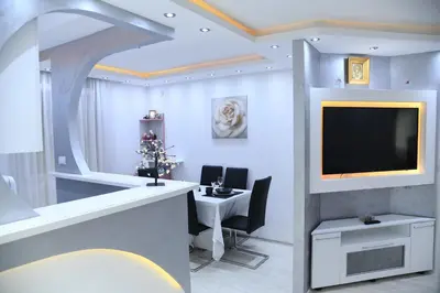a living room with a television and a table with chairs at Apartment 