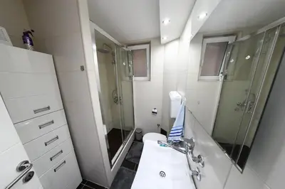 a bathroom with a shower and a toilet and a sink at Apartment 
