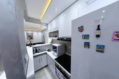 a kitchen with white cabinets and a microwave at Apartment 